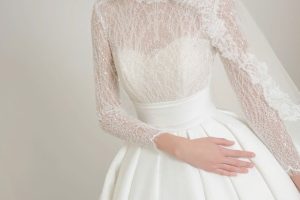 Cô dâu mặc váy cưới ren trắng sang trọng được chụp trong studio.