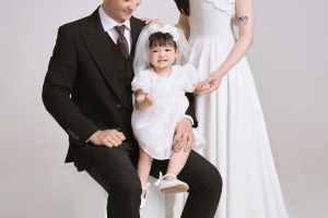 Ảnh chụp gia đình gồm bố, mẹ và em bé với phong cách thanh lịch tại studio.