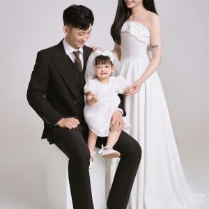 Ảnh chụp gia đình gồm bố, mẹ và em bé với phong cách thanh lịch tại studio.