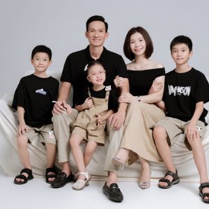 Ảnh chụp gia đình với trang phục tông màu đen và be đồng bộ trong studio.