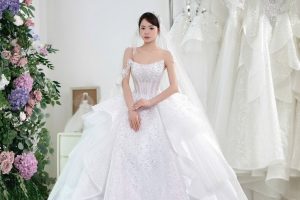 Một cô dâu mặc váy cưới trắng lộng lẫy trong studio.