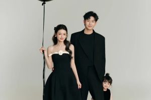 Ảnh chụp gia đình ba người với phong cách tối giản, sang trọng trong trang phục tông màu đen trên nền trắng.