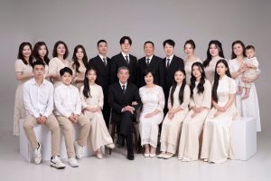 Ảnh chụp gia đình nhiều thế hệ với trang phục tông màu trắng và kem thanh lịch trong studio.