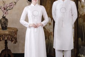 Cặp đôi mặc áo dài trắng truyền thống chụp ảnh tại studio.