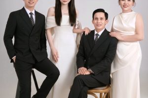 Bốn người mặc trang phục sang trọng chụp ảnh chân dung tại studio.