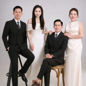 Bốn người mặc trang phục sang trọng chụp ảnh chân dung tại studio.