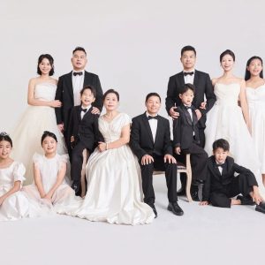 Ảnh chụp gia đình đông đủ thành viên với trang phục trắng và đen sang trọng trong studio.